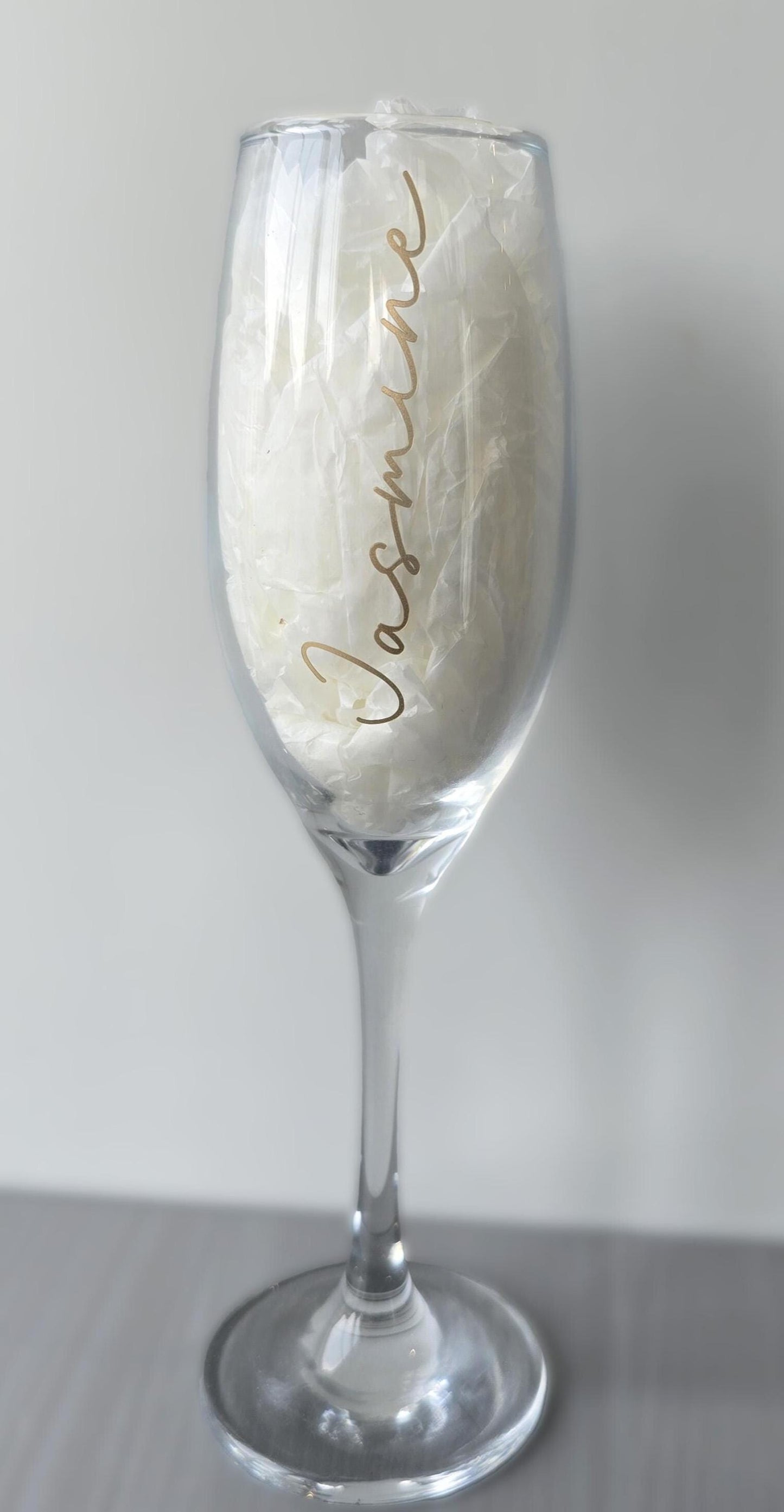 Personalised prosecco or champagne flute glasses with a name in glitter or metallic decorative font on the side of the glass.