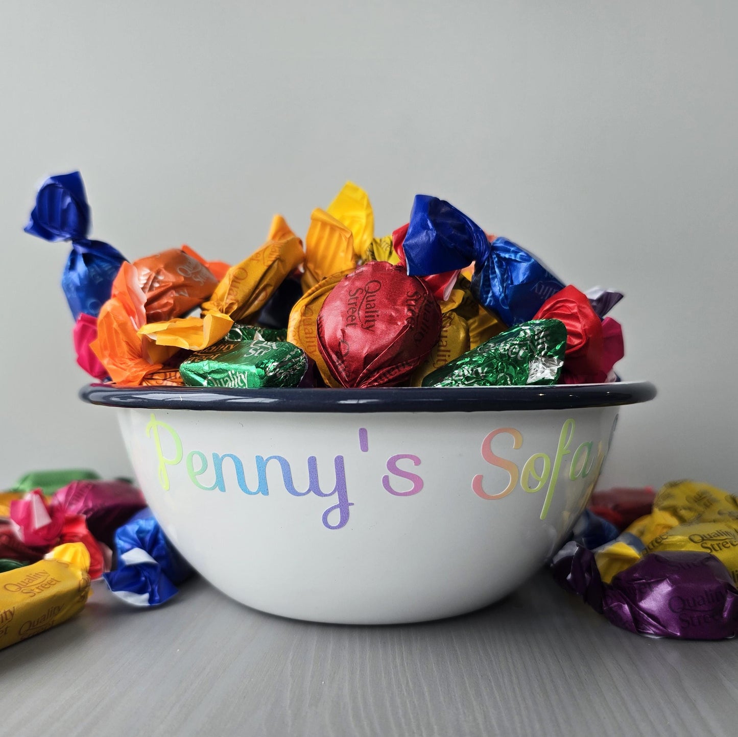 White steel enamel metal snack bowls with sofa snacks printed in rainbow decorative font.