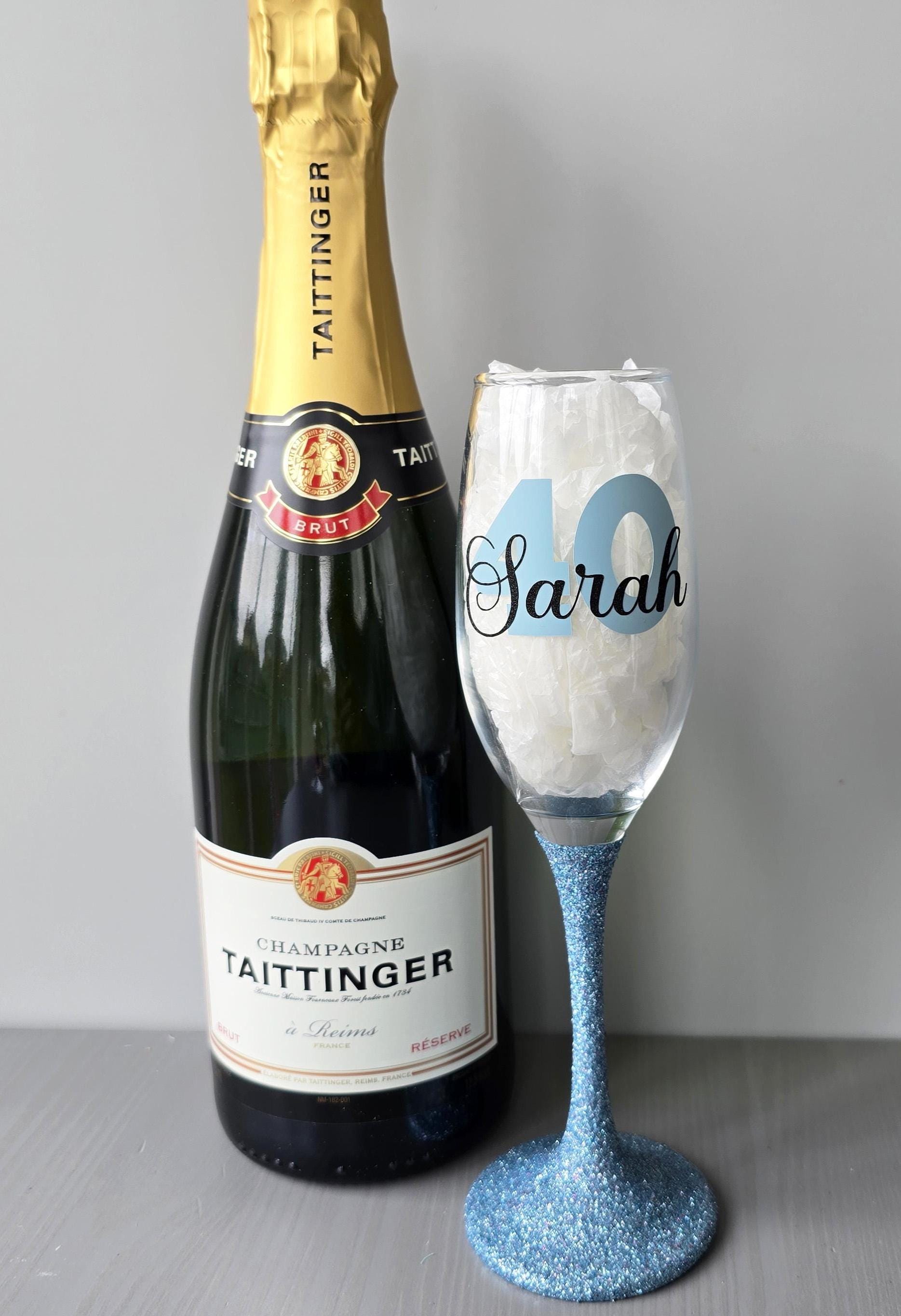 Personalised champagne flute or prosecco glass with glitter stem and with a birthday age number in block, glitter or metallic vinyl and a name in black decorative font through the number