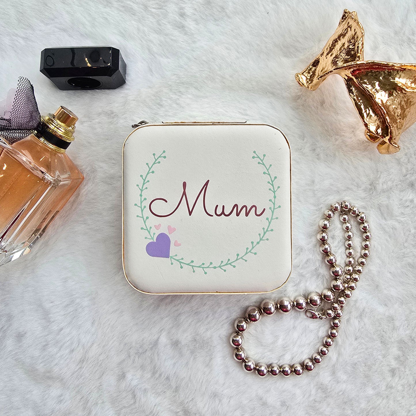 Faux leather, travel jewellery box personalised with a name in the middle of a decorative circle, decorated with hearts. Travel size jewellery case with zip and internal jewellery dividers.