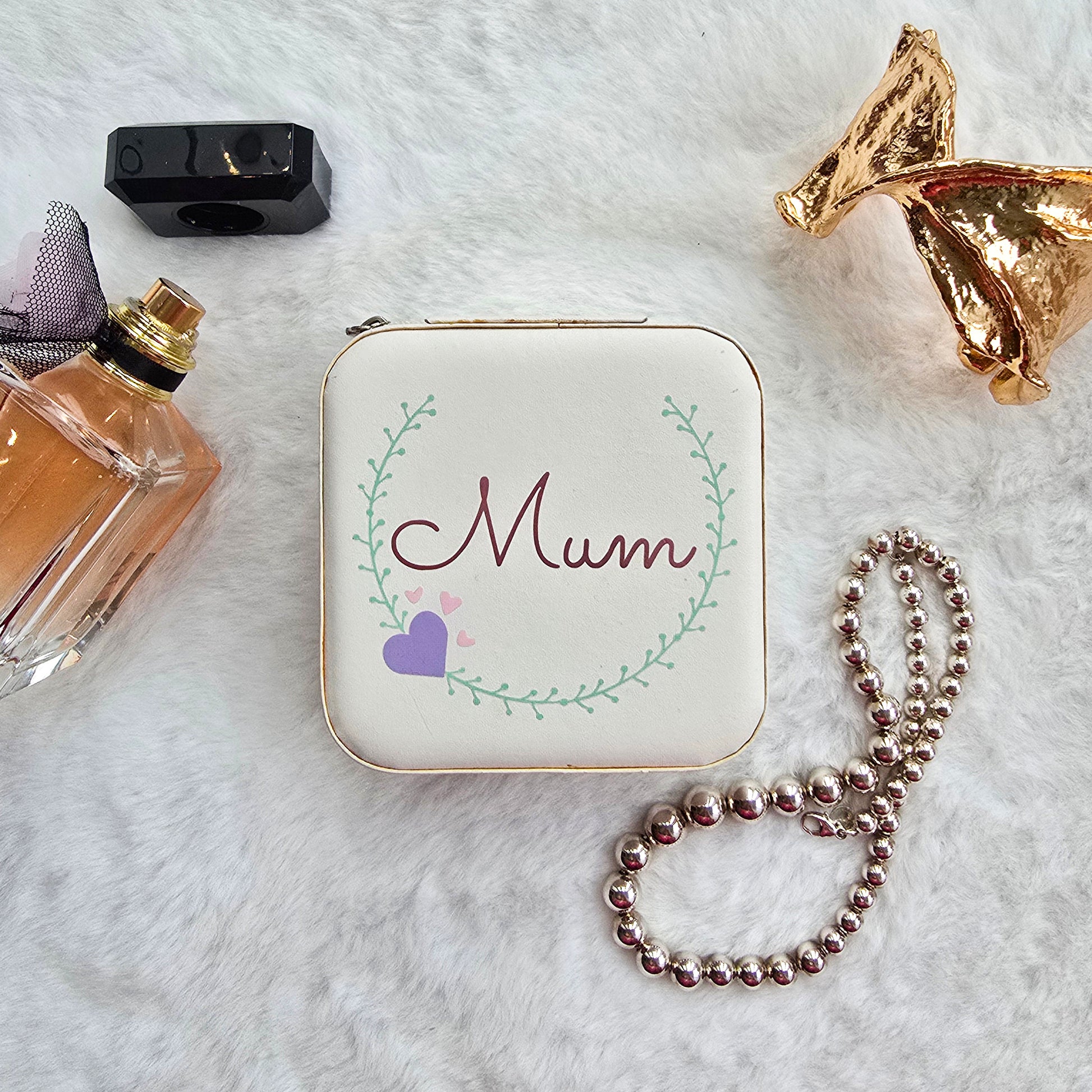 Faux leather, travel jewellery box personalised with a name in the middle of a decorative circle, decorated with hearts. Travel size jewellery case with zip and internal jewellery dividers.