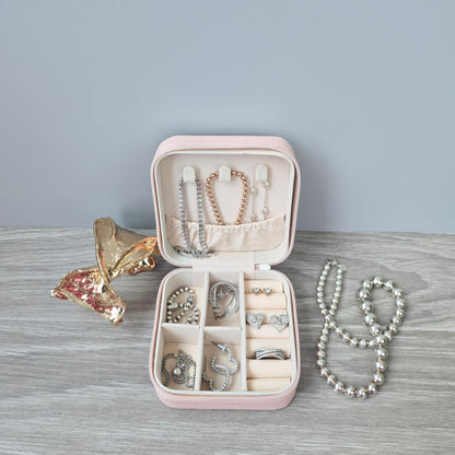 Faux leather, travel jewellery box personalised with a name in the middle of a decorative circle, decorated with hearts. Travel size jewellery case with zip and internal jewellery dividers.