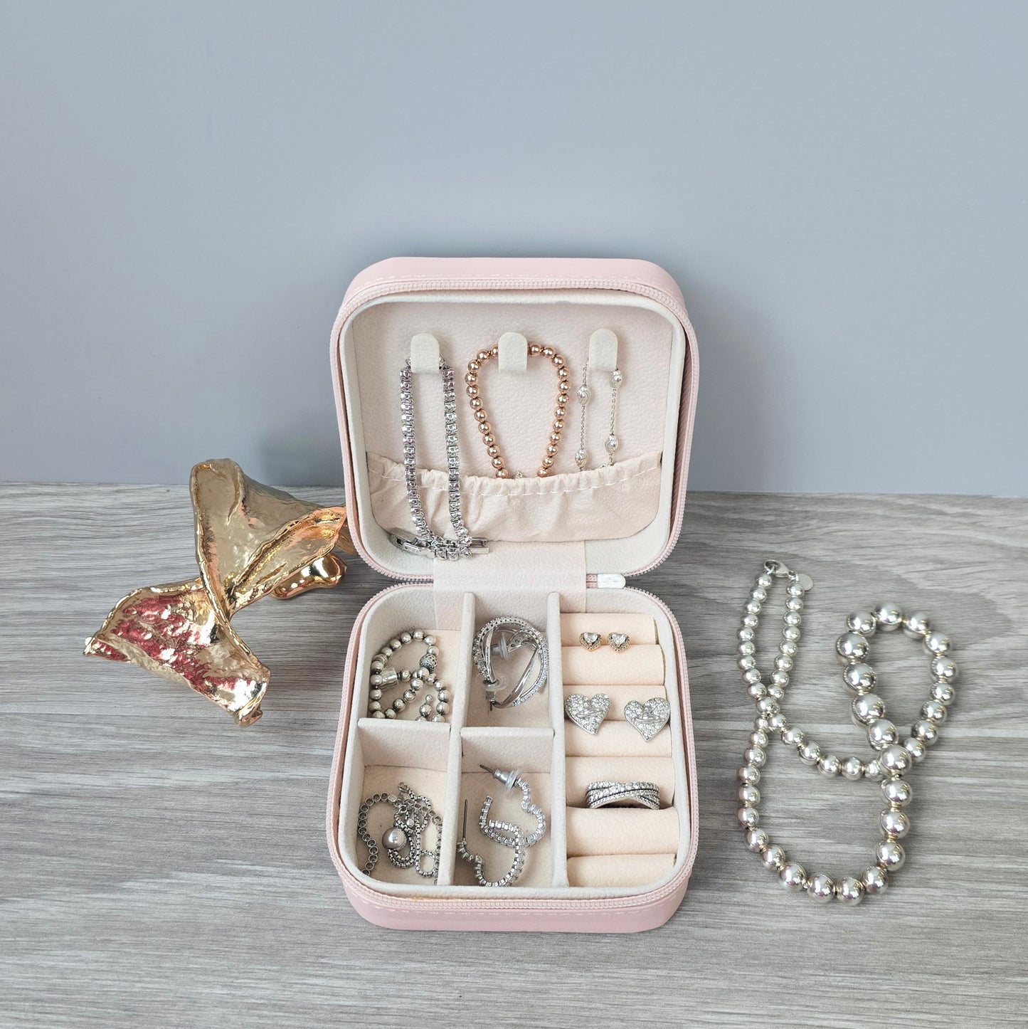 Faux leather, travel jewellery box personalised with a name in the middle in the bottom corner. Travel size jewellery case with zip and internal jewellery dividers.