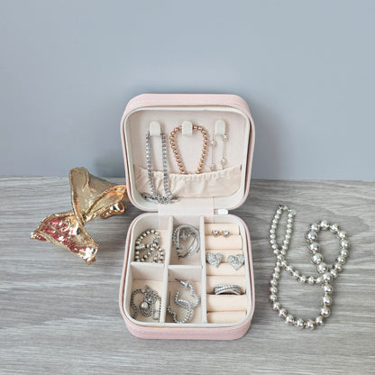Faux leather, travel jewellery box personalised with a name in the middle in the bottom corner. Travel size jewellery case with zip and internal jewellery dividers.