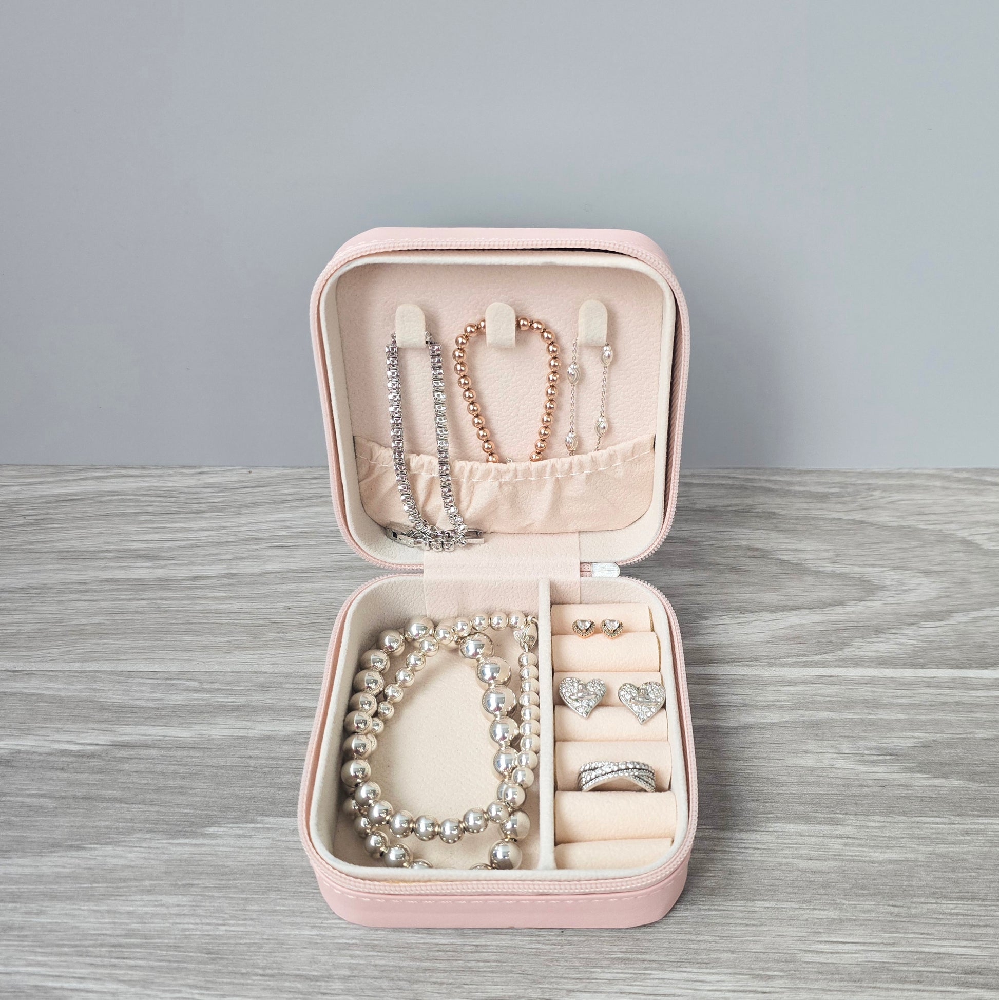 Faux leather, travel jewellery box personalised with a name in the middle in the bottom corner. Travel size jewellery case with zip and internal jewellery dividers.
