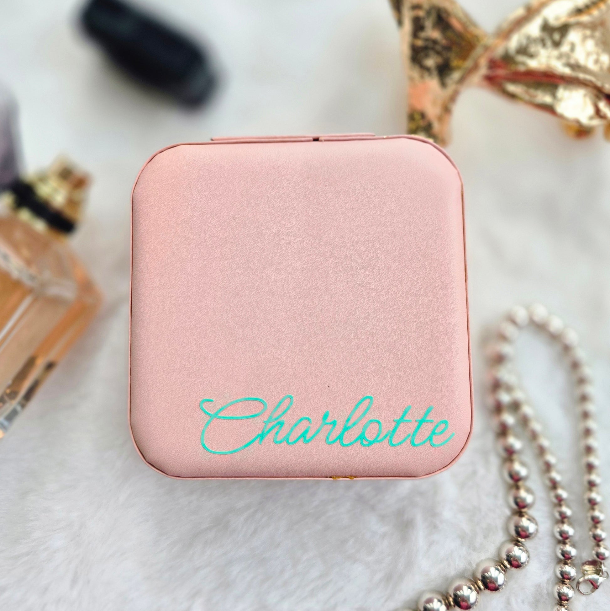 Faux leather, travel jewellery box personalised with a name in the middle in the bottom corner. Travel size jewellery case with zip and internal jewellery dividers.