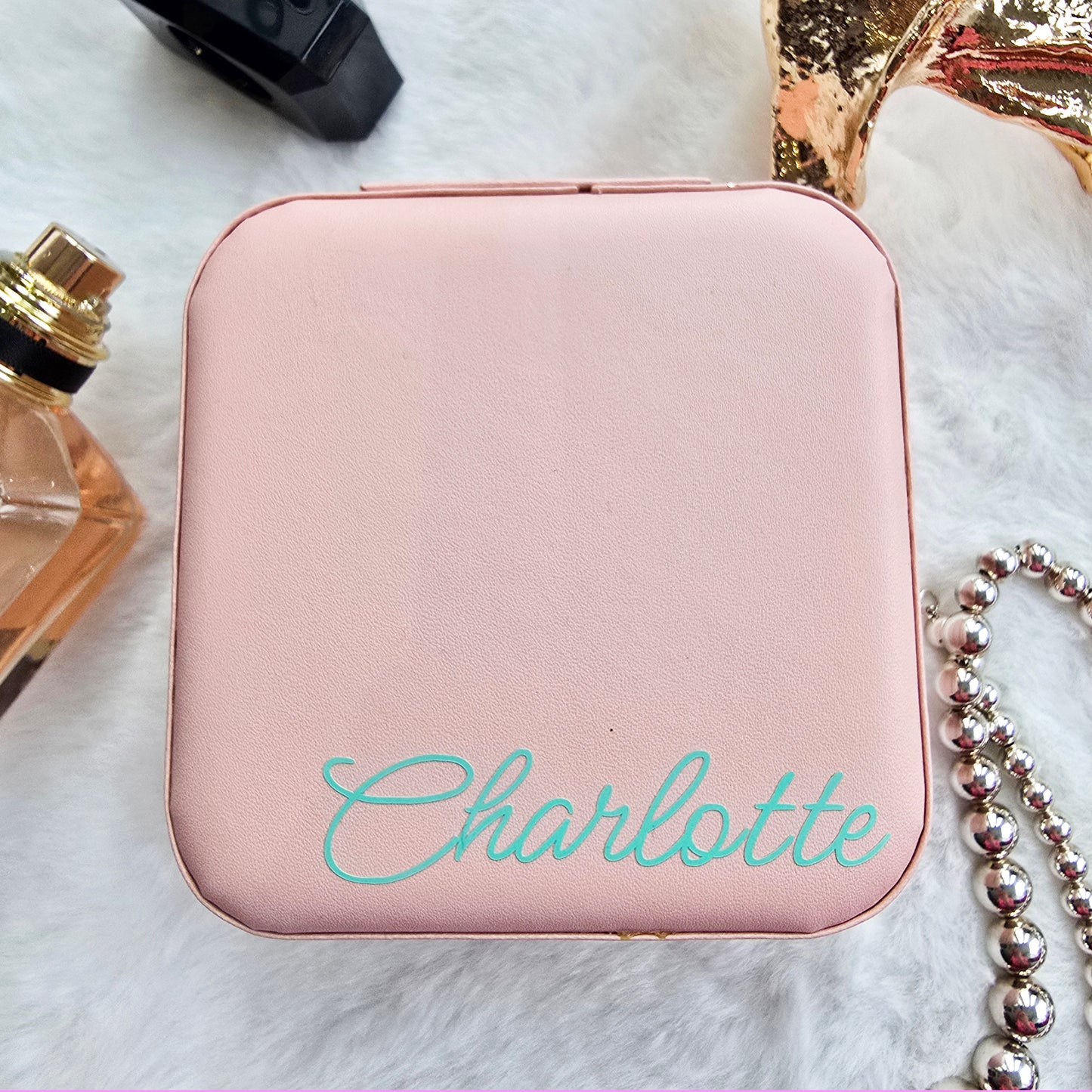 Faux leather, travel jewellery box personalised with a name in the middle in the bottom corner. Travel size jewellery case with zip and internal jewellery dividers.