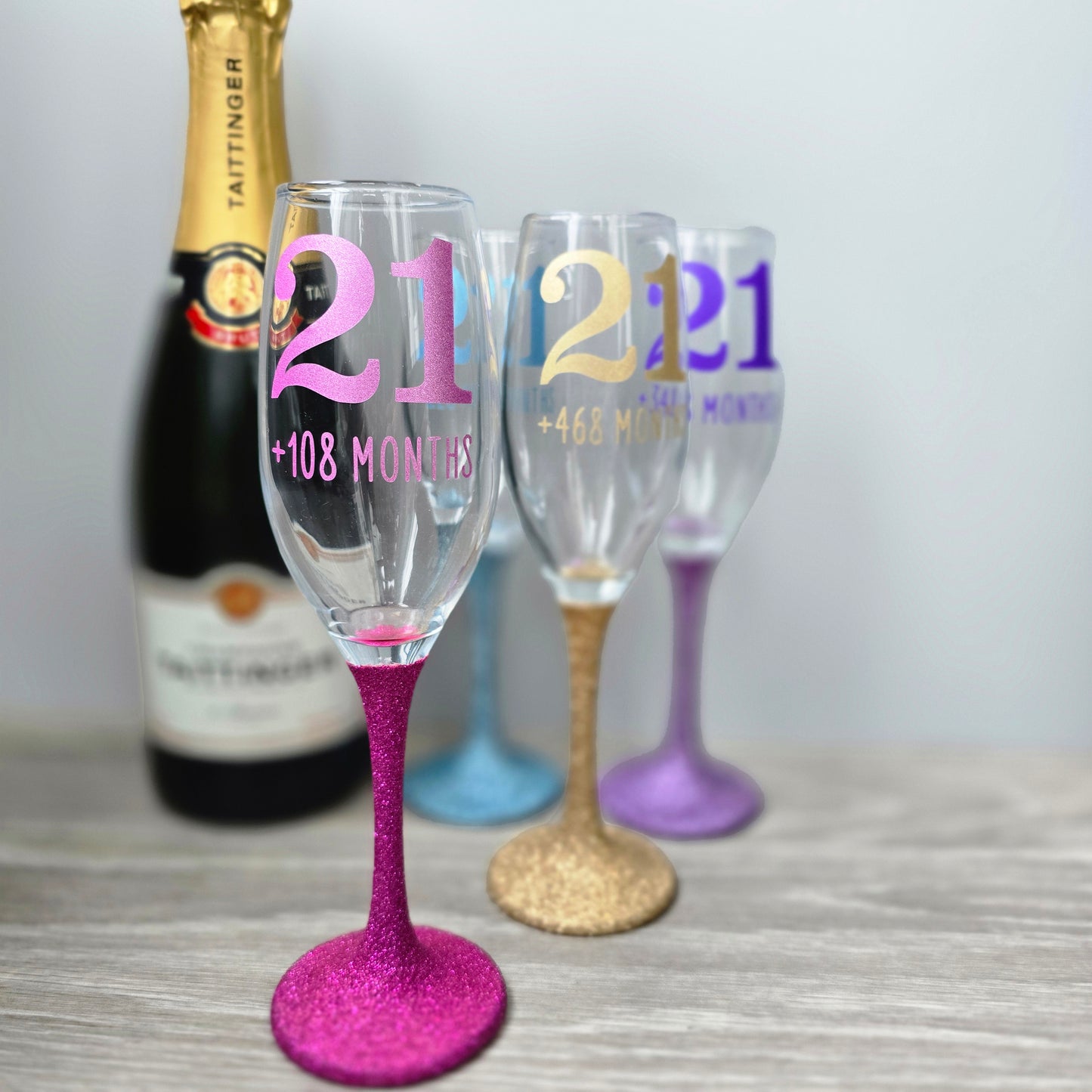 Prosecco glass or Champagne flute decorated with high shine glitter stem and personalised with 21 + the number of months to make up a 30th, 40th, 50th, 60th or 70th Birthday.