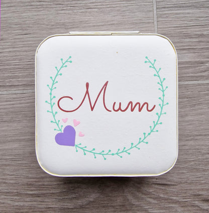 Faux leather, travel jewellery box personalised with a name in the middle of a decorative circle, decorated with hearts. Travel size jewellery case with zip and internal jewellery dividers.