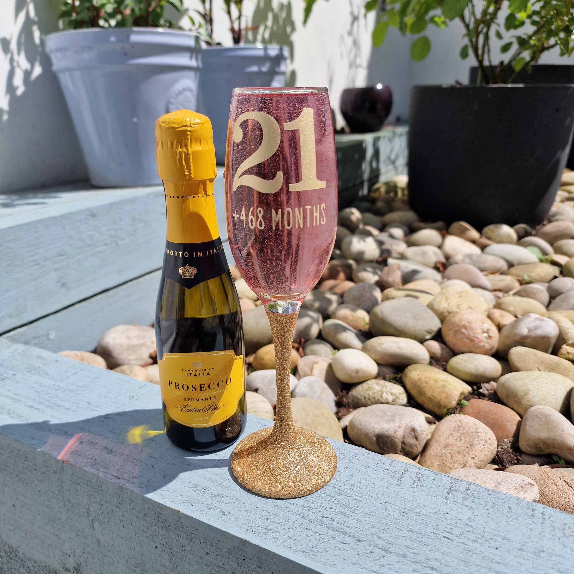 Prosecco glass or Champagne flute decorated with high shine glitter stem and personalised with 21 + the number of months to make up a 30th, 40th, 50th, 60th or 70th Birthday.