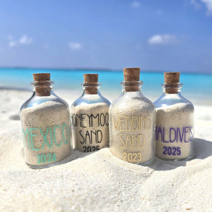 Four bottles filled with sand from different locations on a beach