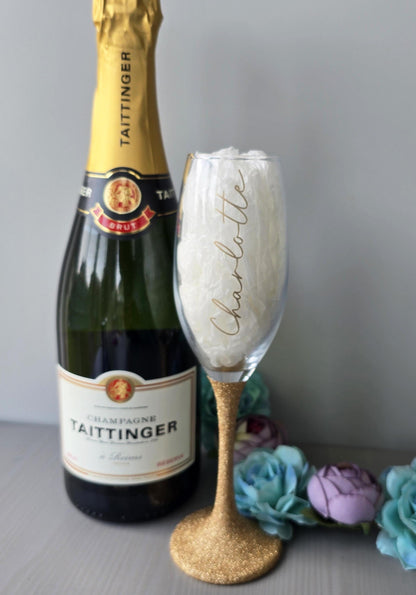 Personalised glitter stem prosecco or champagne flute glasses with a name in glitter or metallic decorative font on the side of the glass.
