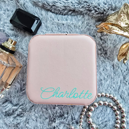 Faux leather, travel jewellery box personalised with a name in the middle in the bottom corner. Travel size jewellery case with zip and internal jewellery dividers.