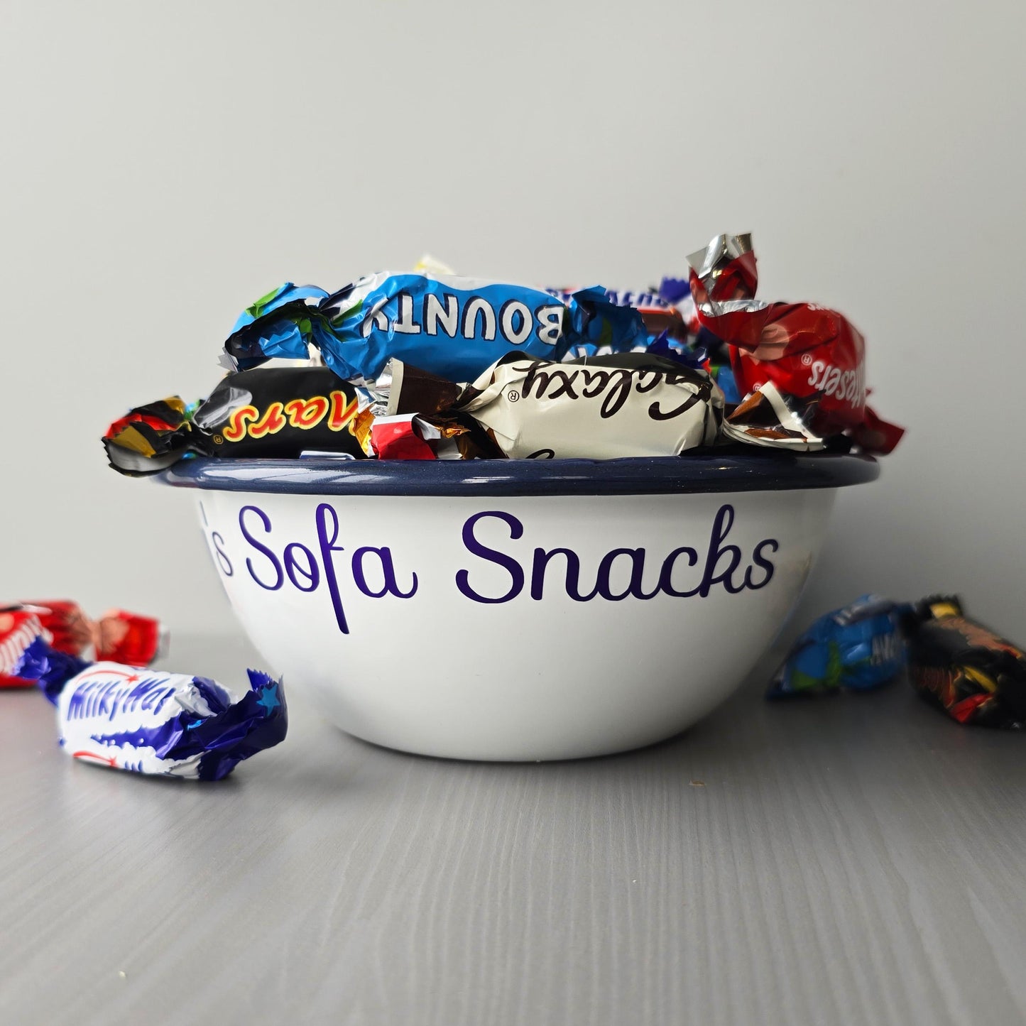White steel enamel metal snack bowls with sofa snacks printed in purple decorative font.