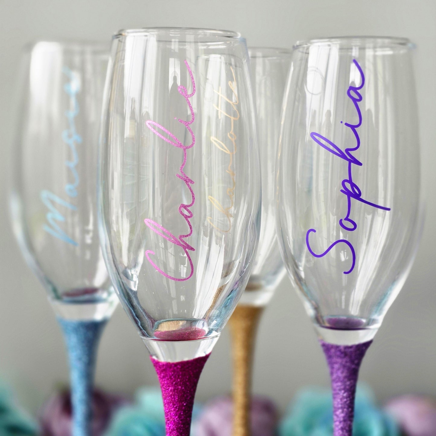 Personalised glitter stem prosecco or champagne flute glasses with a name in glitter or metallic decorative font on the side of the glass.