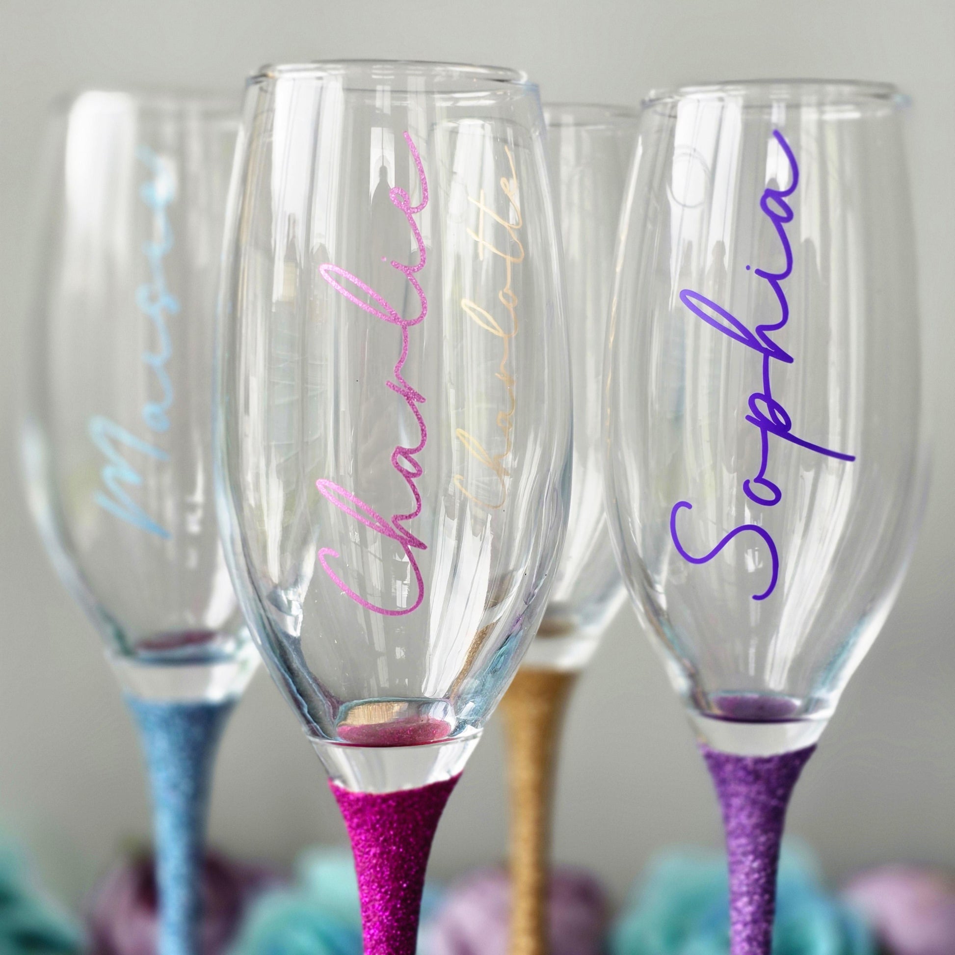 Personalised glitter stem prosecco or champagne flute glasses with a name in glitter or metallic decorative font on the side of the glass.