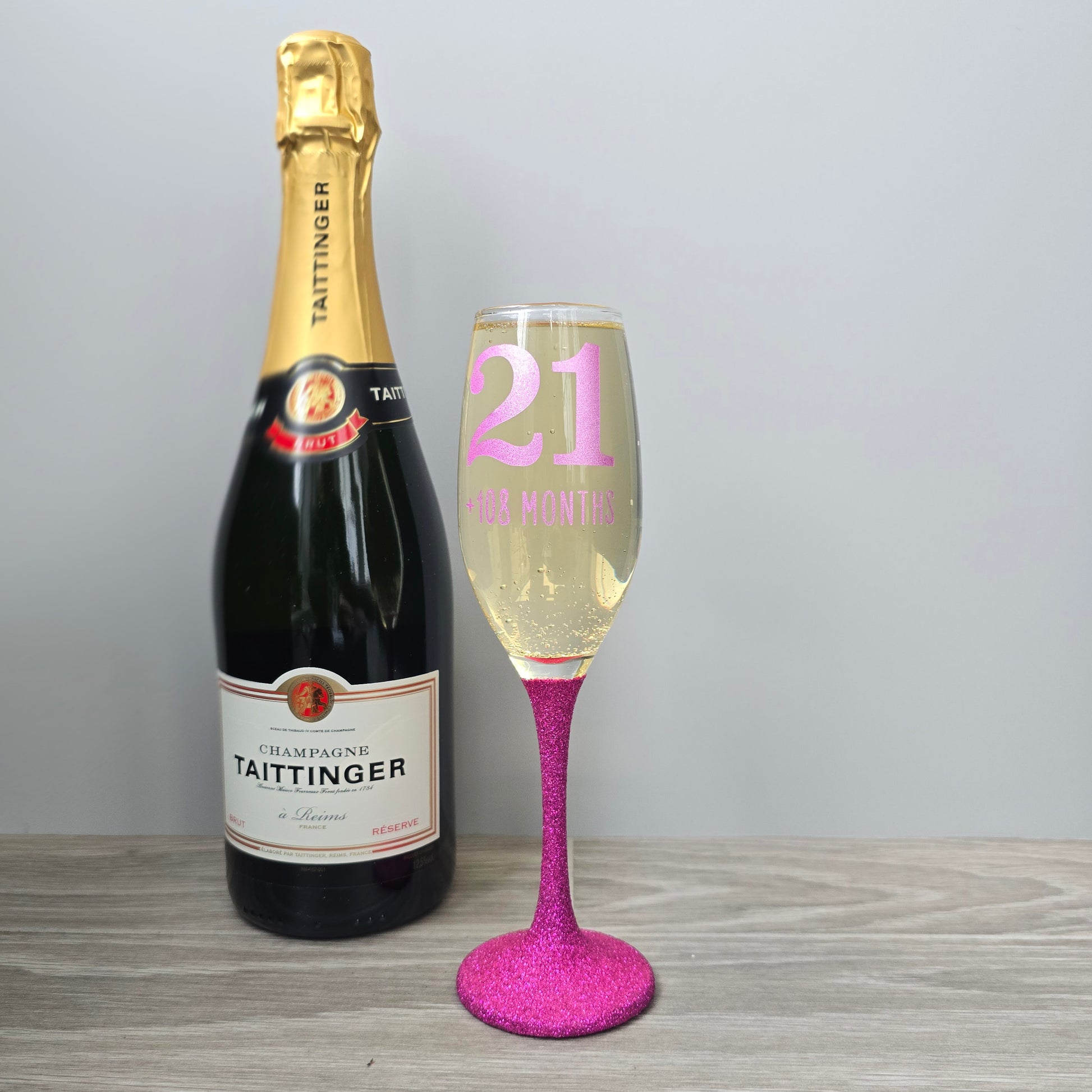 Prosecco glass or Champagne flute decorated with high shine glitter stem and personalised with 21 + the number of months to make up a 30th, 40th, 50th, 60th or 70th Birthday.