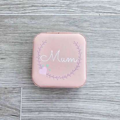 Faux leather, travel jewellery box personalised with a name in the middle of a decorative circle, decorated with hearts. Travel size jewellery case with zip and internal jewellery dividers.