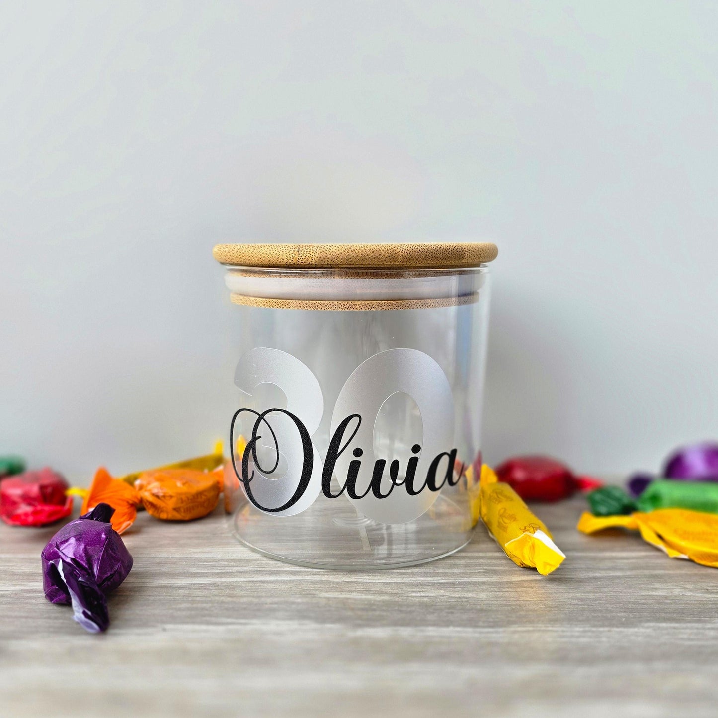 Personalised glass jar with wooden suction lid with a large age and name in  silver and black vinyl