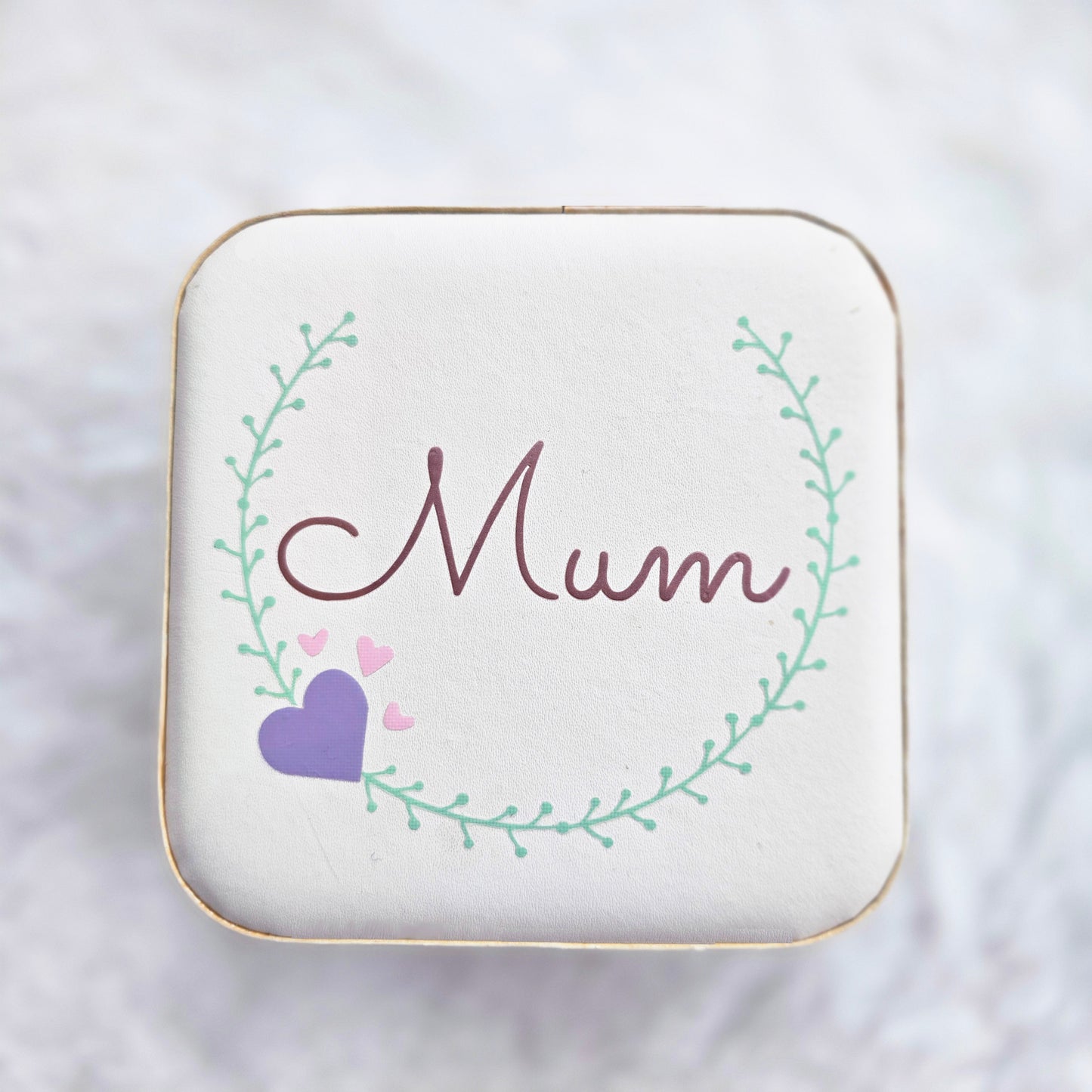Faux leather, travel jewellery box personalised with a name in the middle of a decorative circle, decorated with hearts. Travel size jewellery case with zip and internal jewellery dividers.