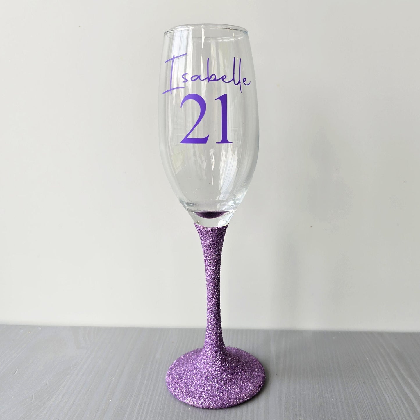 Personalised glitter stem prosecco glass or champagne flute in gold, pink, purple or Blue. Signature style custom name and an age underneath