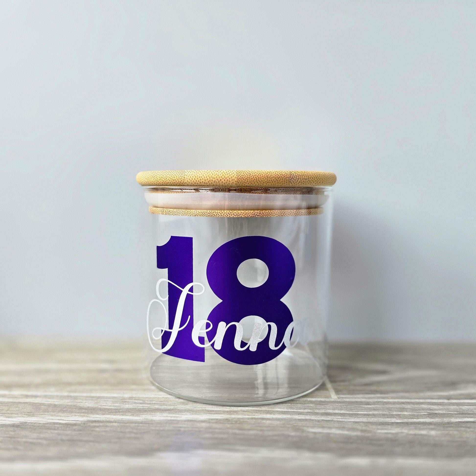 Personalised glass jar with wooden suction lid with a large age and name in purple and silver vinyl