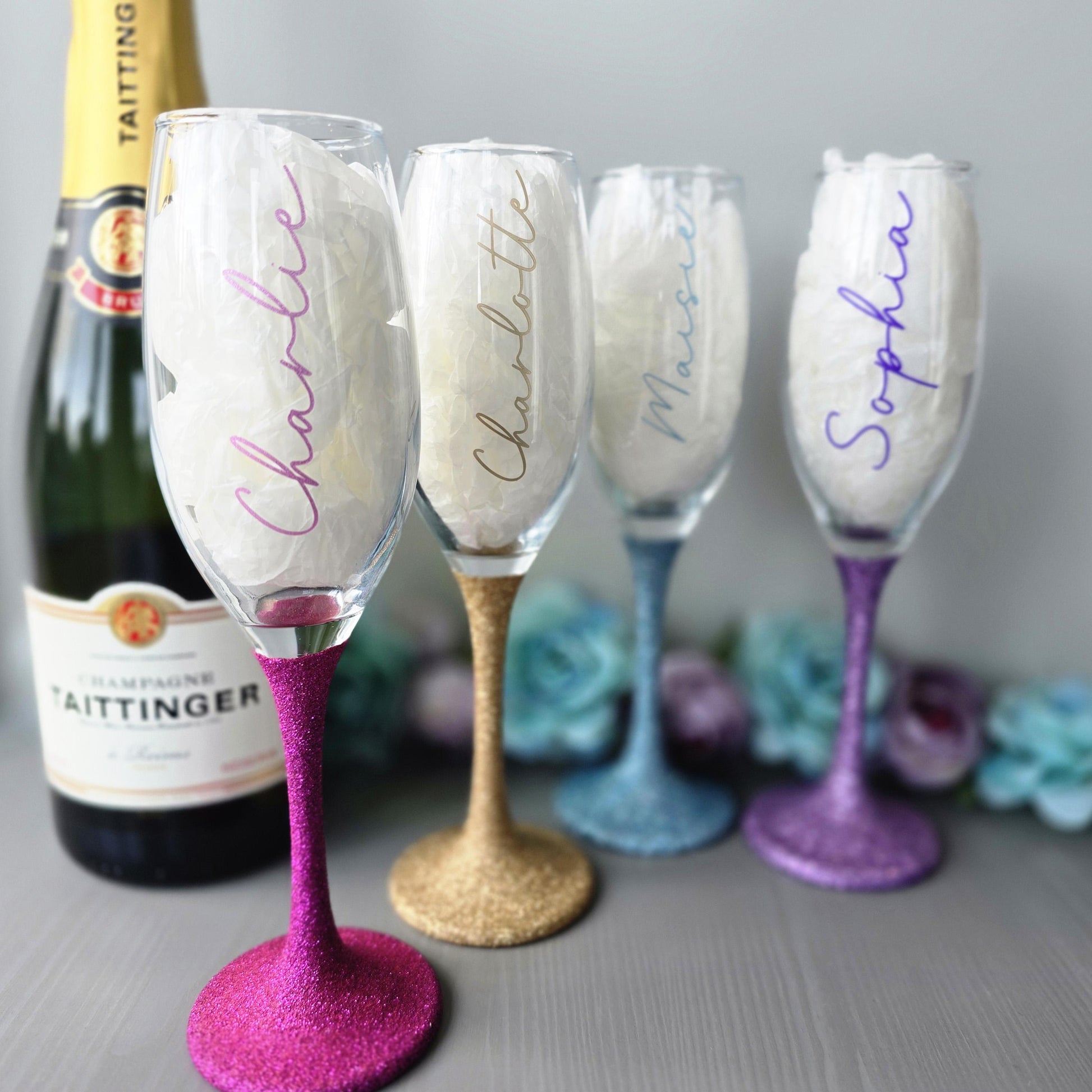 Personalised glitter stem prosecco or champagne flute glasses with a name in glitter or metallic decorative font on the side of the glass.