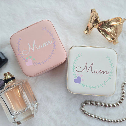 Faux leather, travel jewellery box personalised with a name in the middle of a decorative circle, decorated with hearts. Travel size jewellery case with zip and internal jewellery dividers.