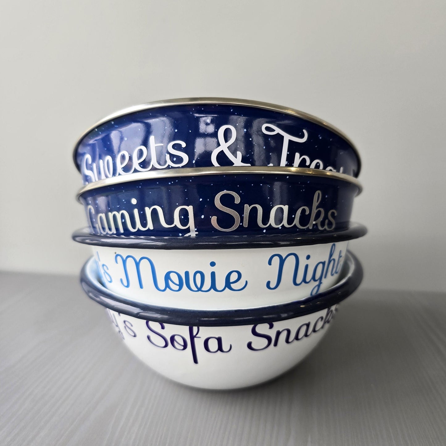 Blue and white steel enamel metal snack bowls with either sweets and treats, gaming snacks, movie night snacks, sofa snacks or pamper night snacks printed in white, silver, blue or purple decorative font.