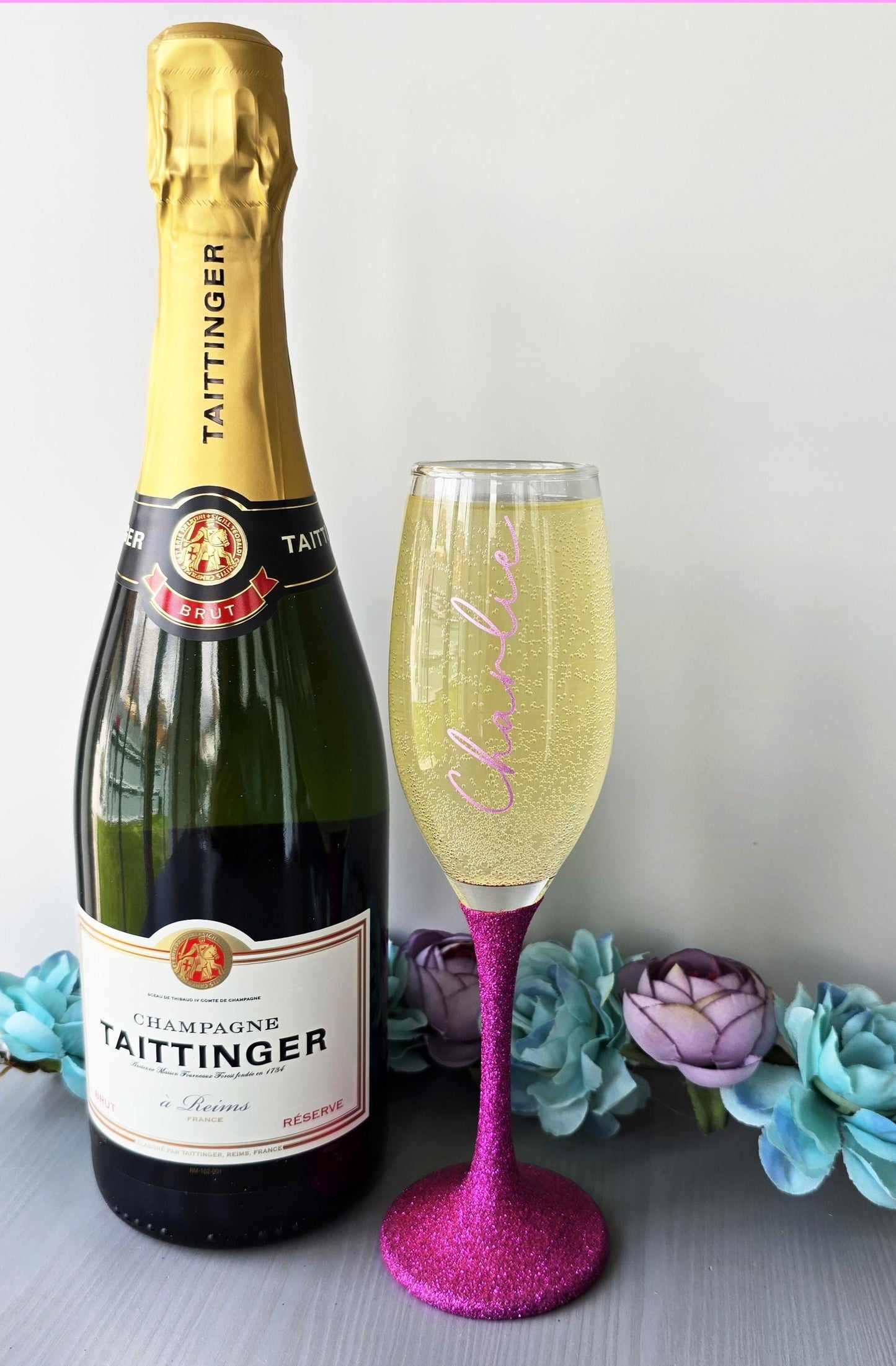 Personalised glitter stem prosecco or champagne flute glasses with a name in glitter or metallic decorative font on the side of the glass.