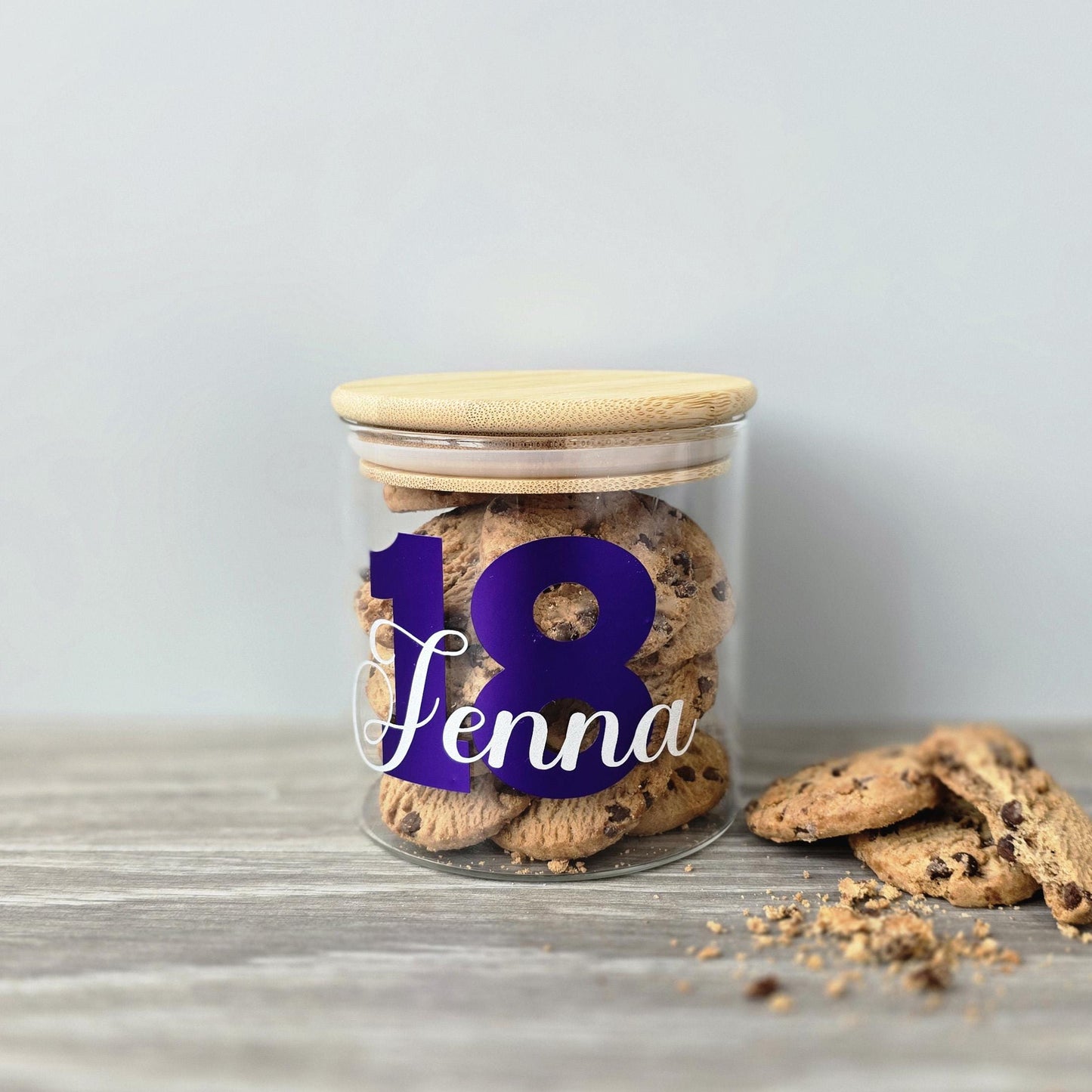 Personalised glass jar with wooden suction lid with a large age and name in purple and silver vinyl