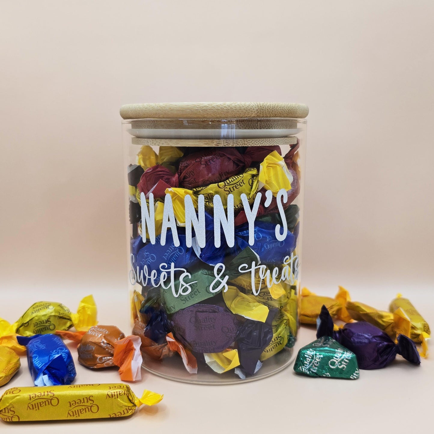 Jar labeled 'Nanny's Sweets & Treats' filled with colorful candies on a light background
