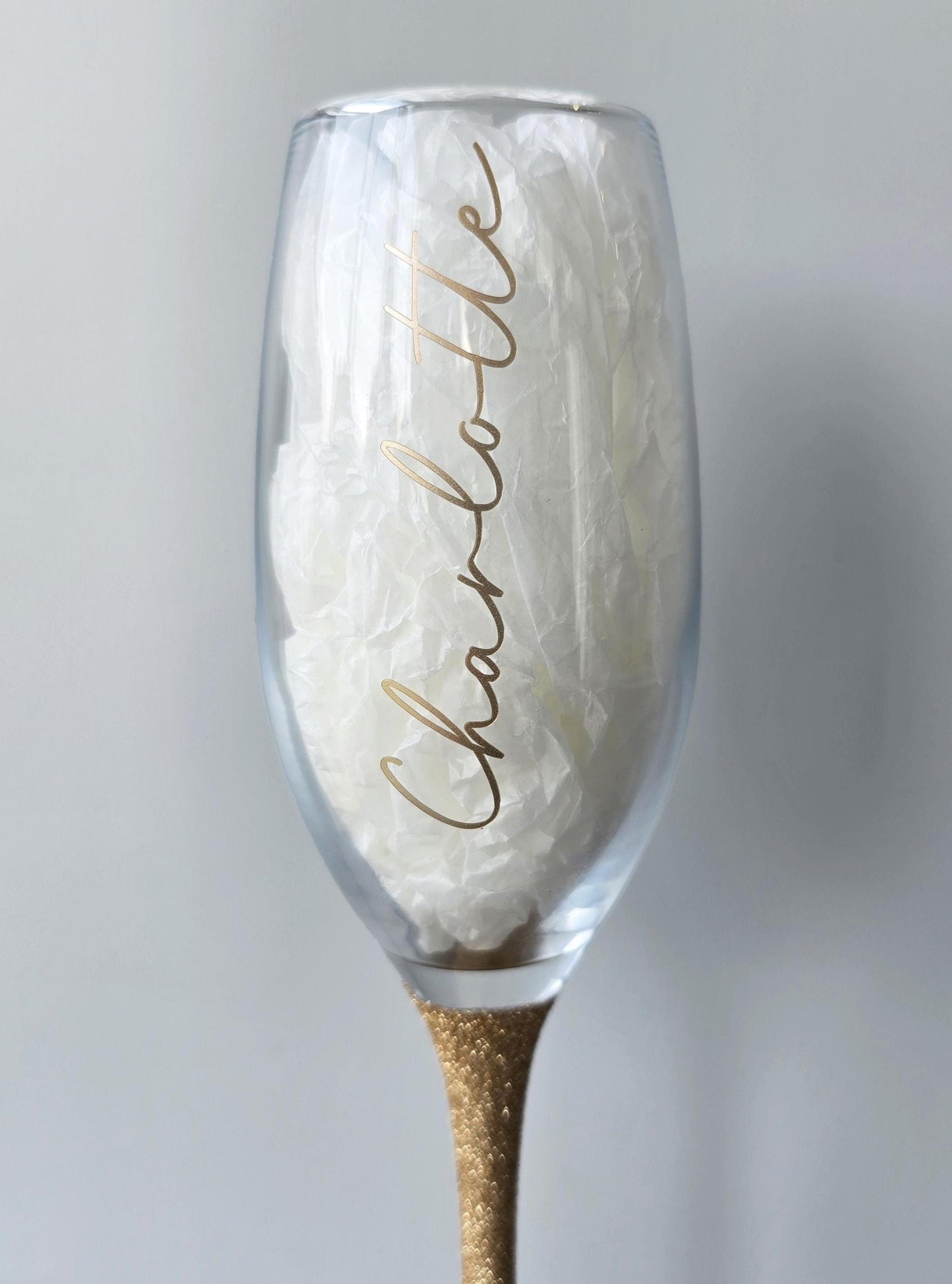 Personalised glitter stem prosecco or champagne flute glasses with a name in glitter or metallic decorative font on the side of the glass.