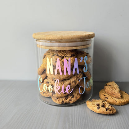 Glass jar labeled 'Nana's Cookie Jar' with cookies on a gray surface