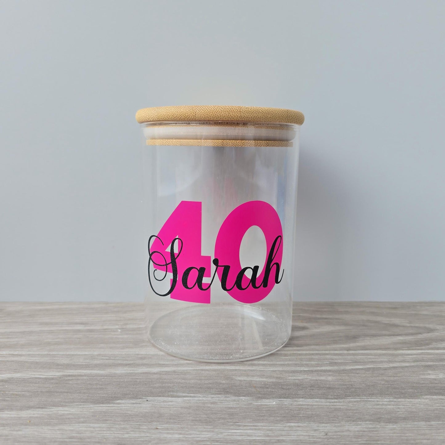 Personalised glass jar with wooden suction lid with a large age and name in pink and black vinyl
