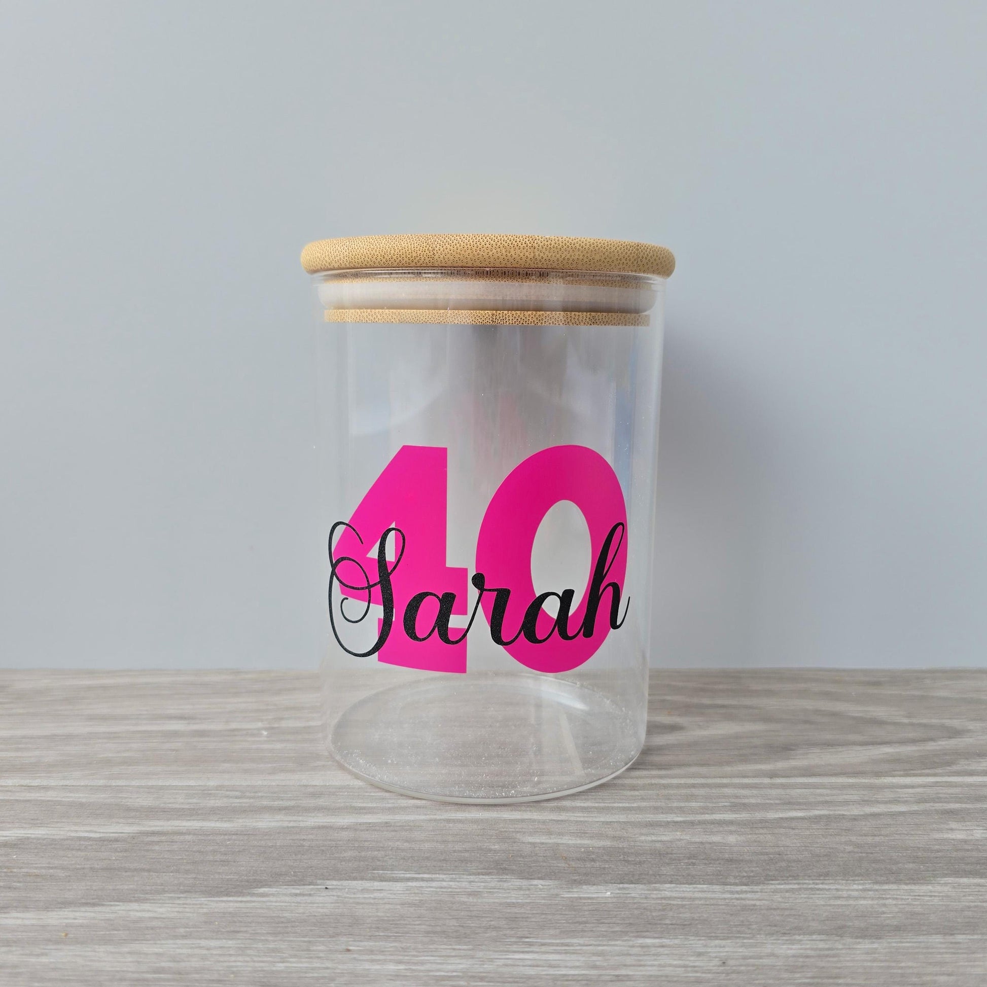 Personalised glass jar with wooden suction lid with a large age and name in pink and black vinyl