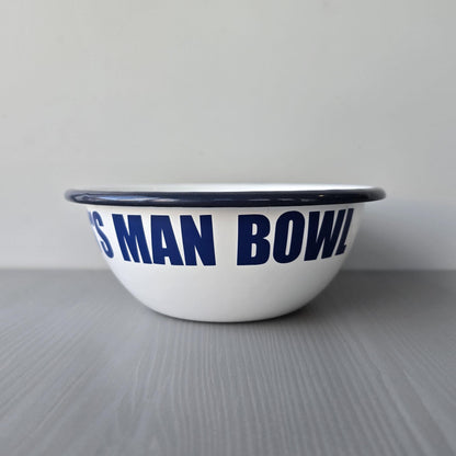 White enamel metal bowl with blue rim and text personalised with a name and 'MAN BOWL' on a grey surface.